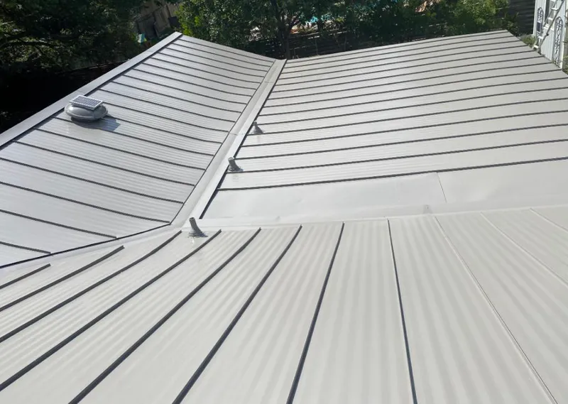 Solar attic fan installed on a metal roof for Roof Ventilation in Cedarhurst